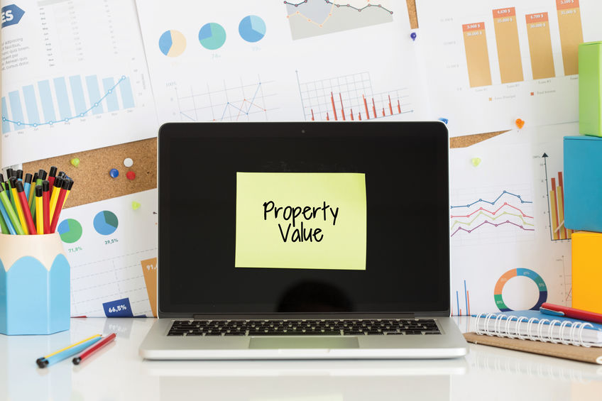 PROPERTY VALUE sticky note pasted on the laptop scree