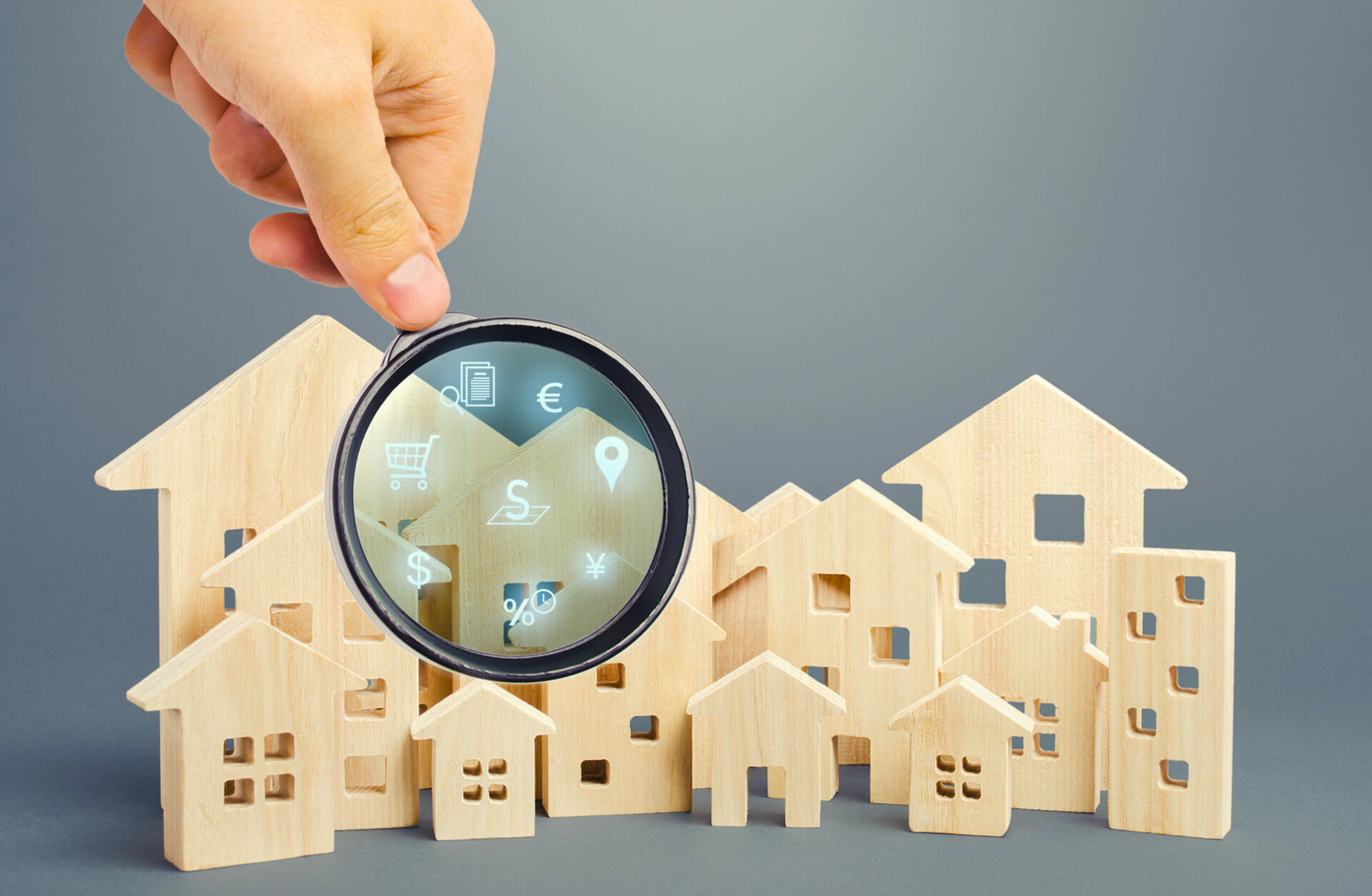 Realtor examines houses through a magnifying glass. Review of the real estate market, search for the best offers based on the criteria of price, location, area, infrastructure. Customer preferences.